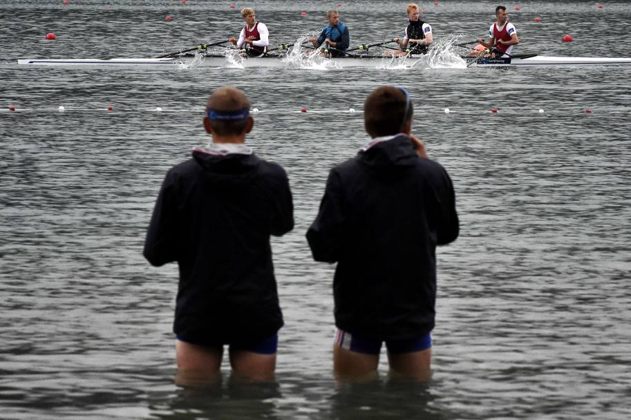Canottieri con le gambe nell’acqua osservano gli allenamenti dei compagni ad Aiguebelette-le-Lac, dove sono in svolgimento i Mondiali di canottaggio (Afp)